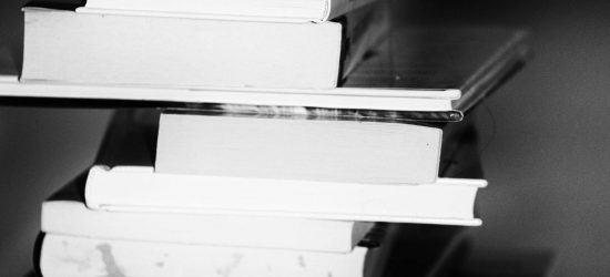 A monochrome image of a tall stack of books symbolizing education and knowledge.